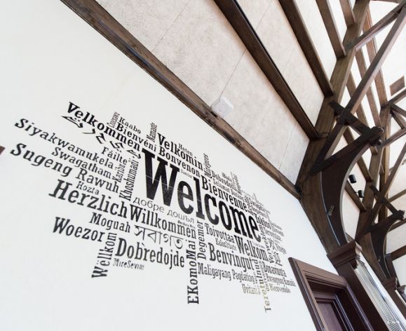 "Welcome" in multiple languages mural on wall
