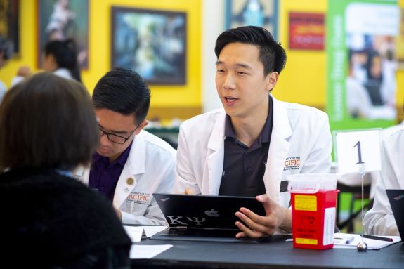 PharmD student with patient at health care outreach clinic