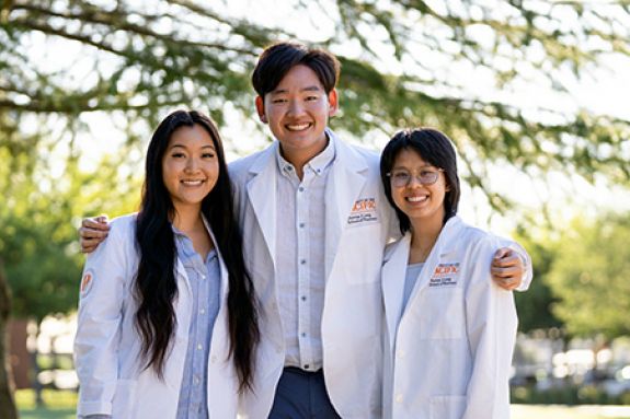Three pharmacy students in white coats