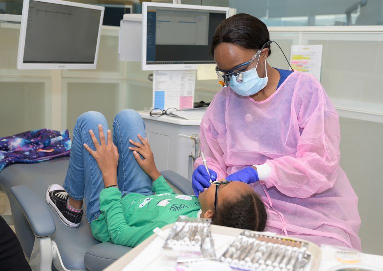 dental hygiene student with child patient