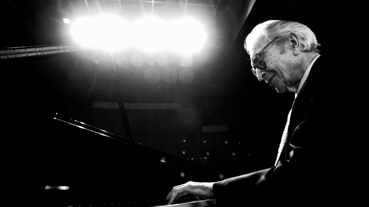 Dave Brubeck is pictured in black and white playing a piano