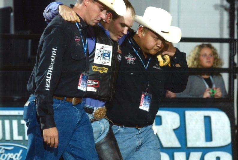 Peter Wang (far right) helps an athlete at a Professional Bull Riders event. 