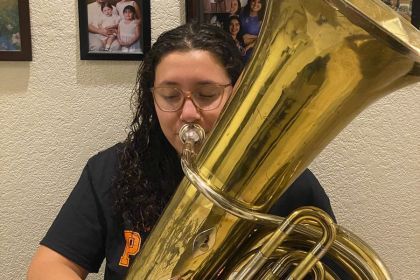 Jolene Villavicencio at home with the tuba the Conservatory of Music loaned her.