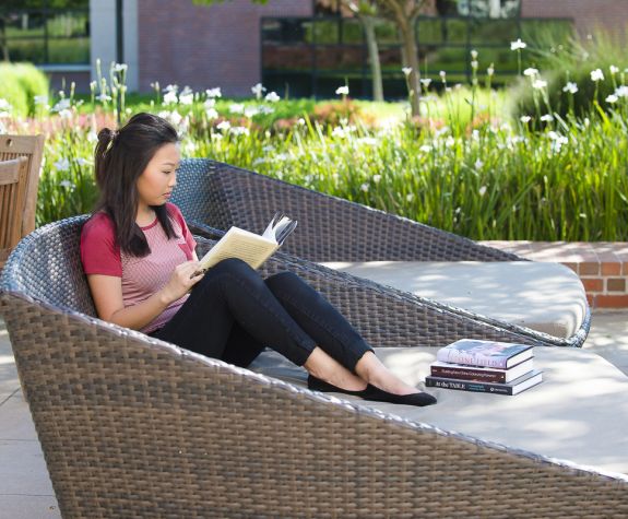 student reading in front of DeRosa Center