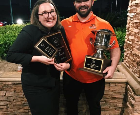 debate team members holding awards