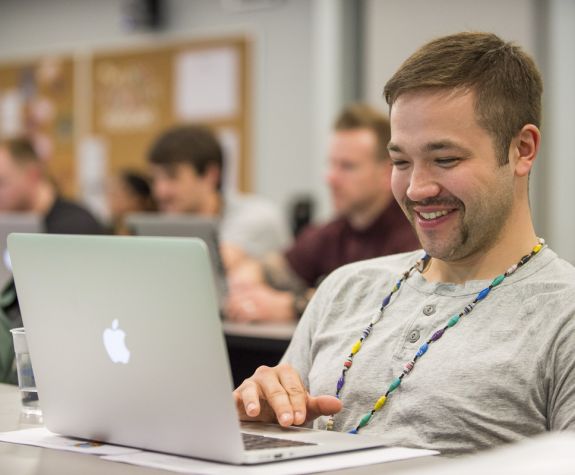 student using laptop and smiling