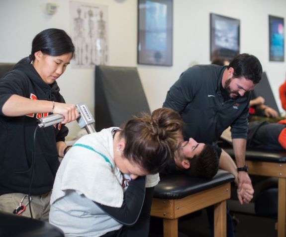 Students administering therapy to athletes