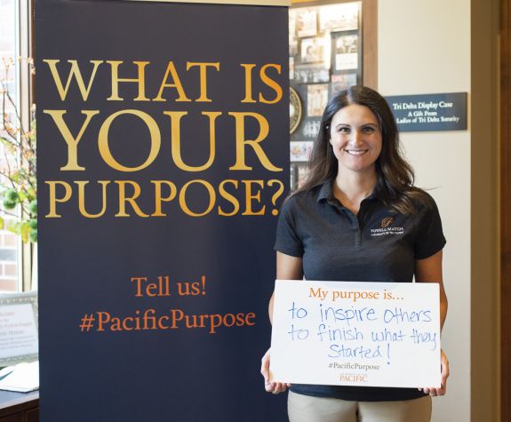 Degree completion student holding sign that says "My purpose is to inspire others to finish what they started"