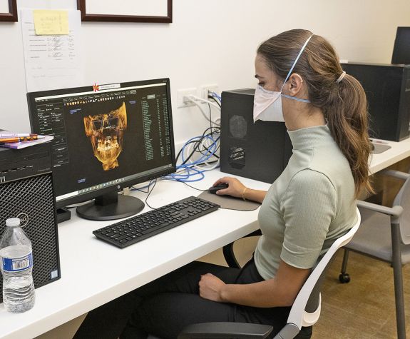 woman sitting at computer looking at orthodontics imaging