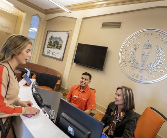 student and two staff members at one stop student center