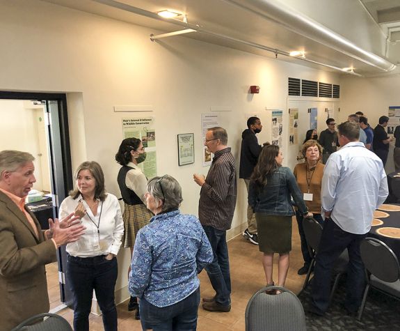 Muir Symposium; people are mingling and talking as students present their research
