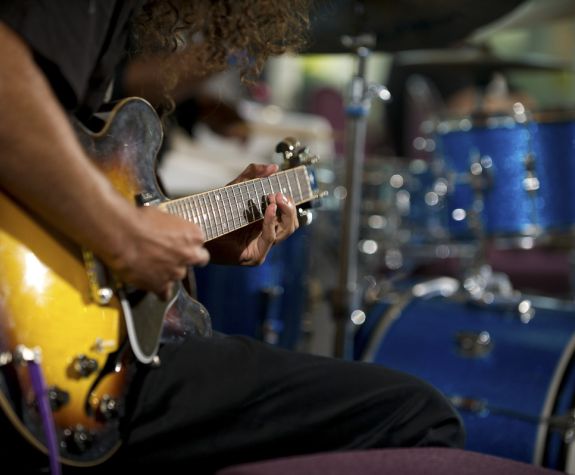 persons playing the guitar and a drum kit