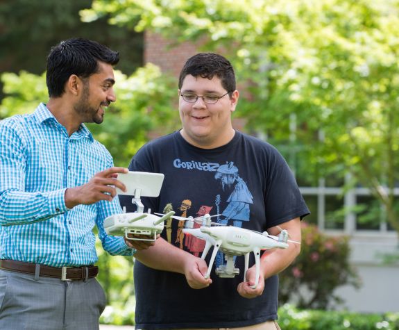 Dean Niraj Chaudhary and student working with a drone
