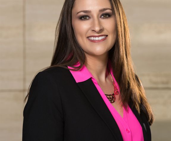 A woman in a suit poses for a photo