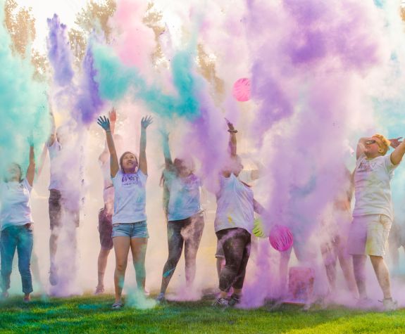 students throw colors into the air