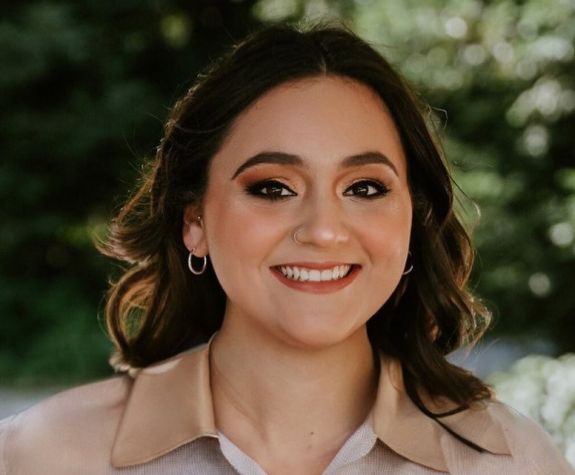 A portrait of a woman wearing a button down shirt 