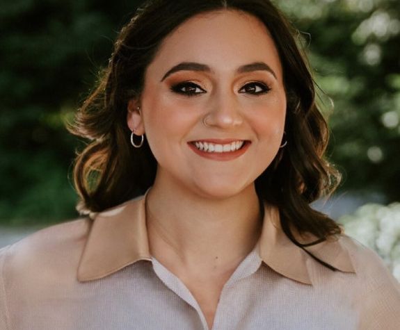 A portrait of a woman wearing a button down shirt 