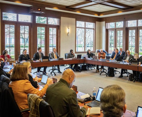 a board of regents meeting taking place in a large room