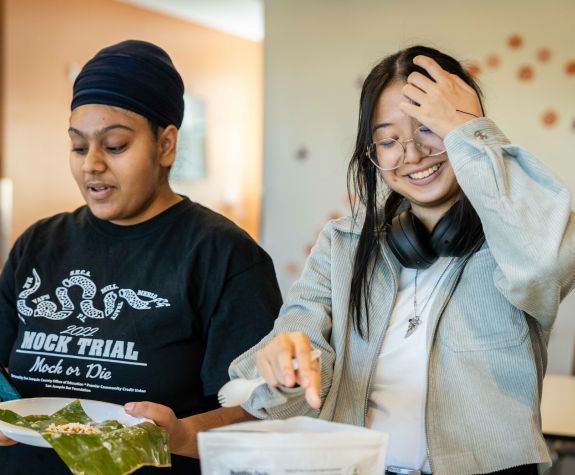 Two female students cooking together.