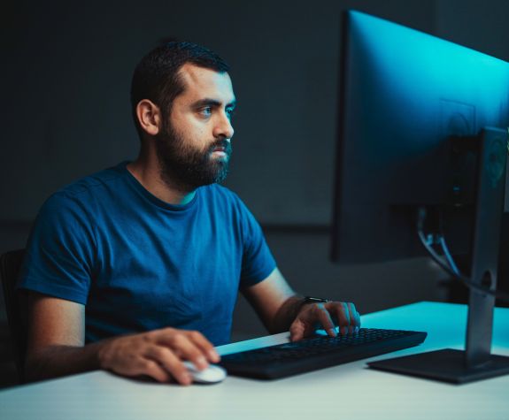 Cybersecurity student works on a computer in the lab