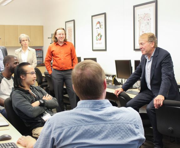 Students gather around a guest lecturer in Cybersecurity class
