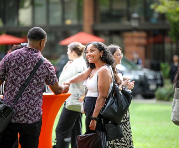 students networking outdoors, shaking hands
