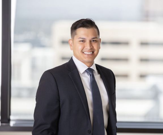 Man in black suit smiles for the camera