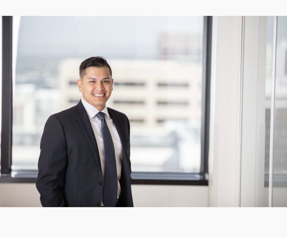Man in black suit smiles for the camera