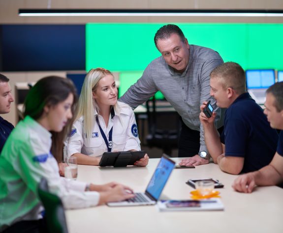 Image shows a group of people gathered around a table. 