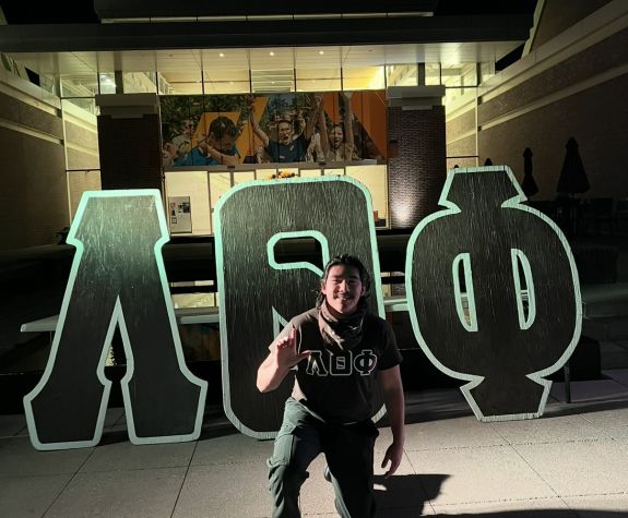 man standing in front of greek letters 