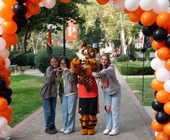 students standing under a balloon arch