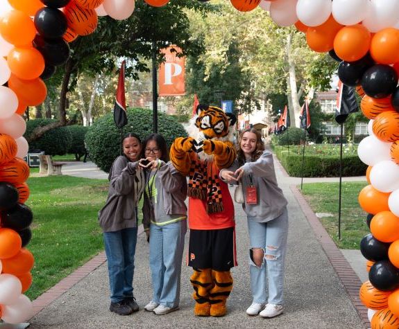 students standing under a balloon arch