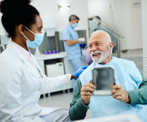 smiling older man with beard talking to dentist