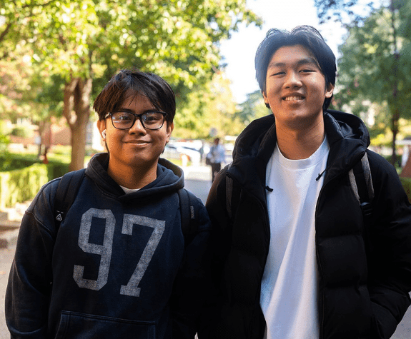 Two students smile at the camera