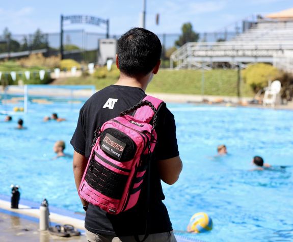 An athletic training student stands by a pool