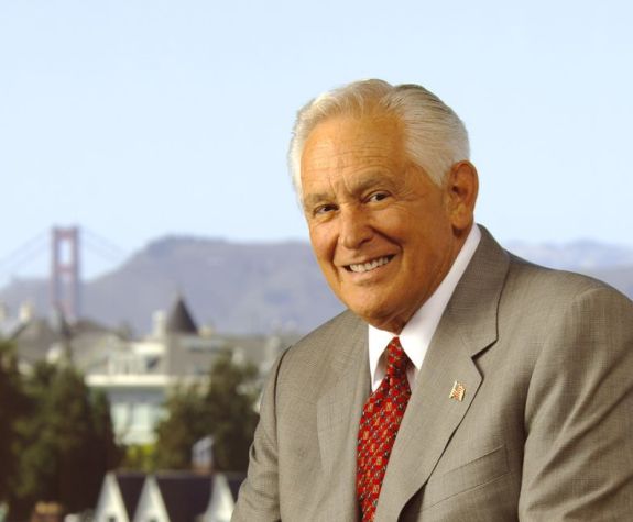 Arthur Dugoni, seated, with a backdrop of the golden gate bridge behind him