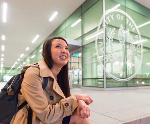 University of the Pacific dental student poses next to the University seal