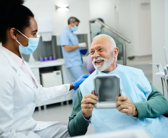 smiling older man with beard talking to dentist