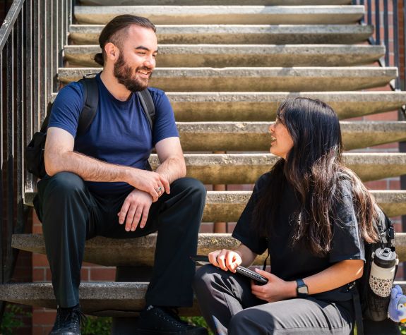 Two PharmD students sit on the steps of the Rotunda