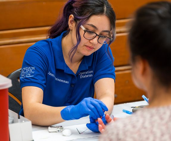 Pharmacy student providing diabetes screening