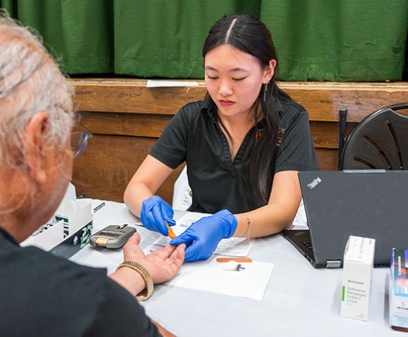 Pharmacy student providing health screening to a patient