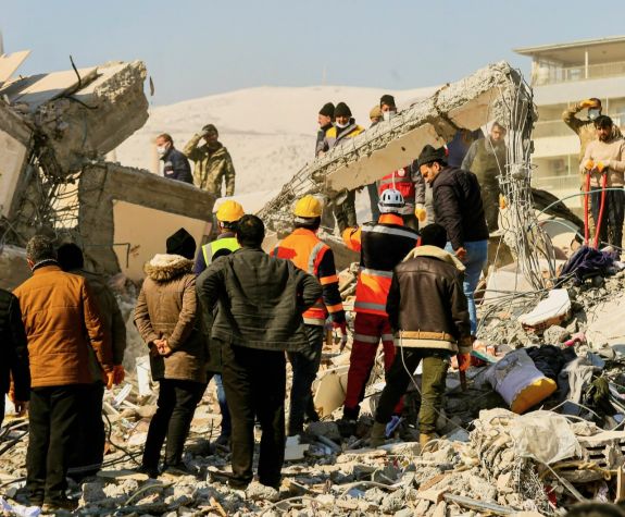Image shows a team of responders working on saving earthquake victims from a building.
