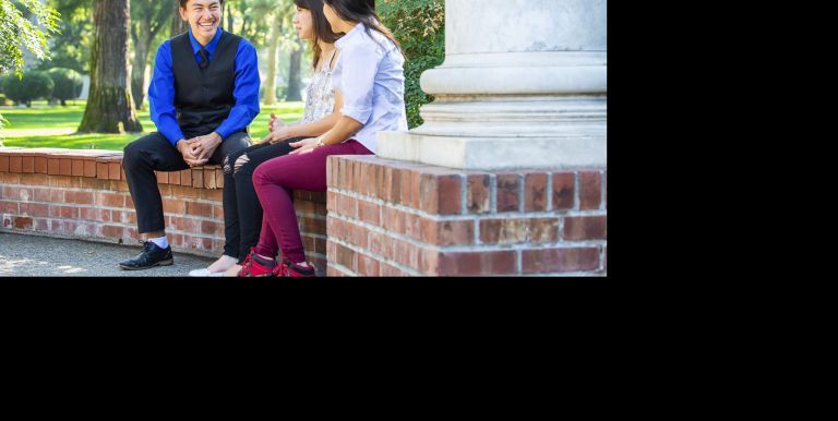 Success TRiO student sitting at columns on campus