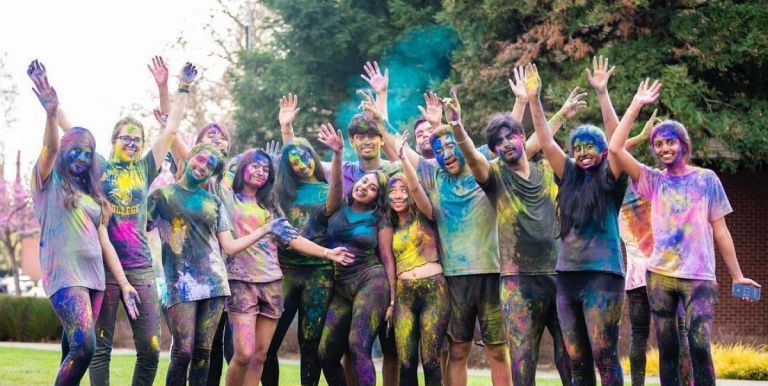 group of students covered in colorful chalk dust