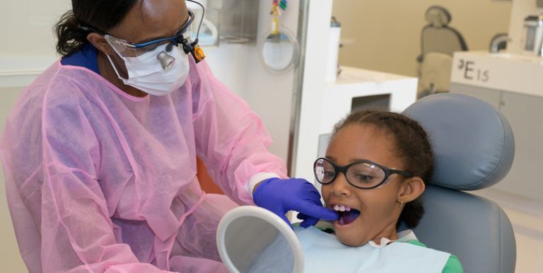 Dugoni student checking a patient's teeth
