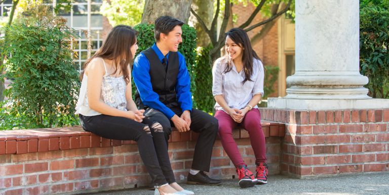 Hispanic students sitting near columns