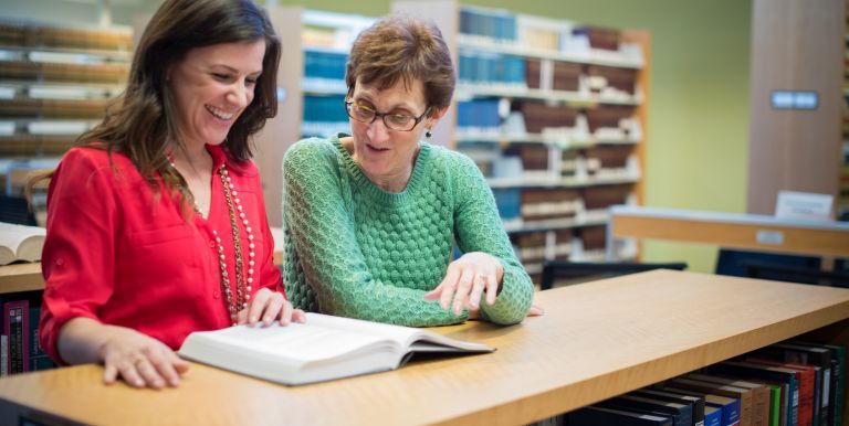 women reading book in law library