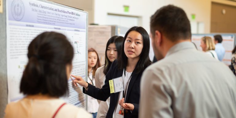 a student presents a poster at PURCC