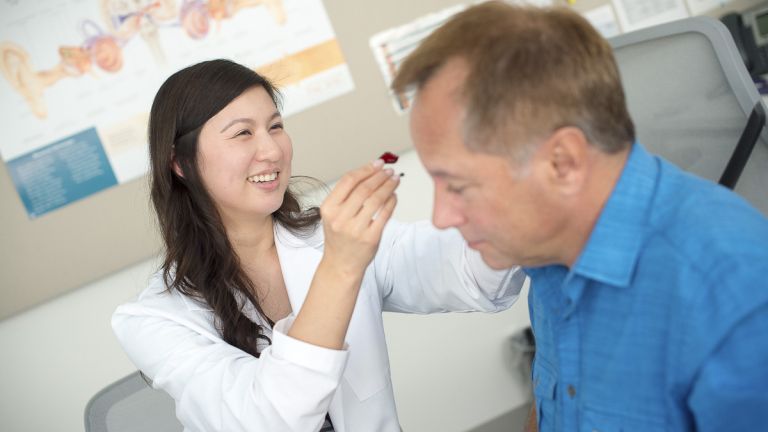 student assisting patient in clinic