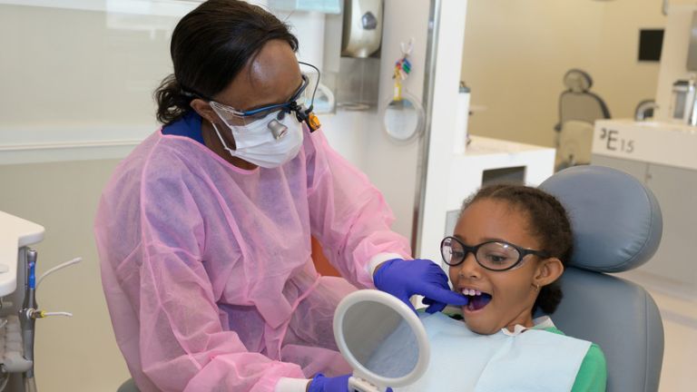 Dugoni student checking a patient's teeth